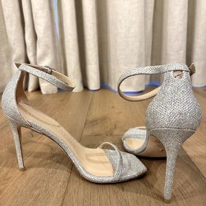 Stuart Weitzman Nudistcurve 100 Sandal in Platino. Glittered mesh, leather sole.